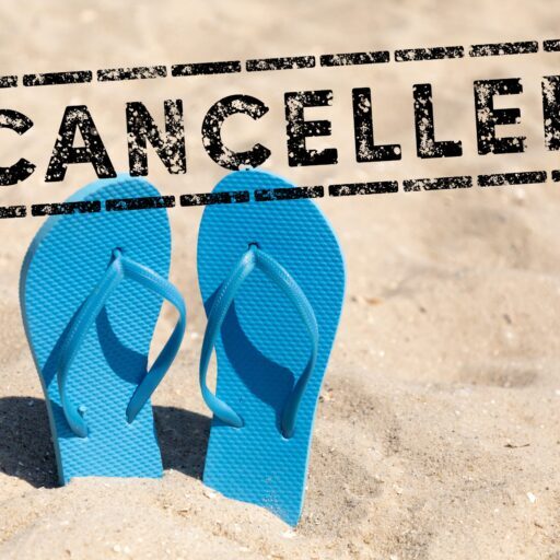 flip flops in the sand and text cancelled - holiday cancel